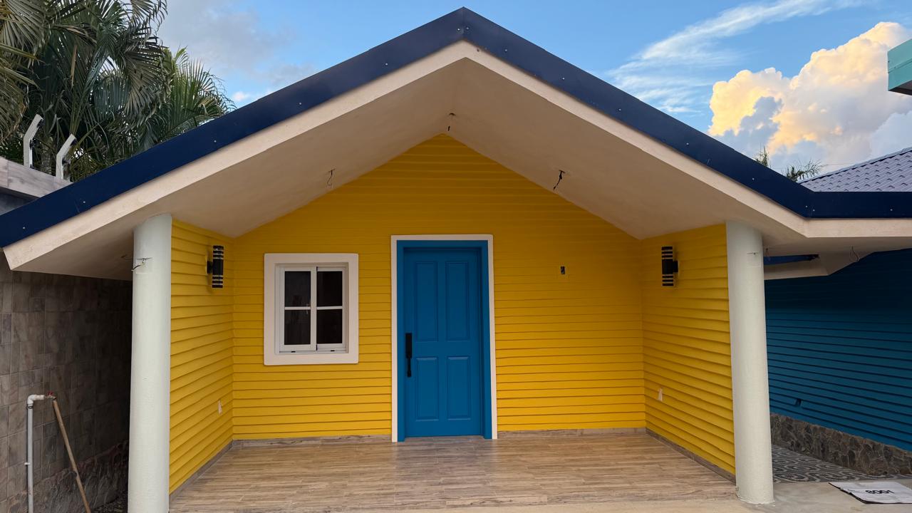 Casita Amarilla con puerta azul y techo azul oscuro